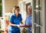 A man and a nurse standing on a porch.