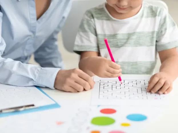 A woman and a child sitting at a table as part of our home healthcare for children aged 3-18.