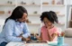 An Americare nurse helping a kid with studying.