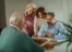 A group of people sitting around a table playing chess.