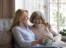 Happy women sitting and talking on a couch.