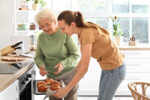 Younger Woman Helping Senior Woman Bake in Home