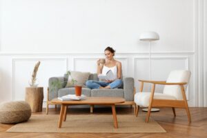 Woman Relaxing on a Sofa Holding a Book and Mug