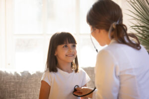 Female Nurse Checking Heart of Little Girl During an In-Home Visit