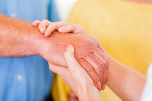  Older hand being held between the hands of a younger person 