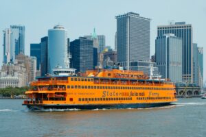 Orange Staten Island ferry floating along the Hudson River with Manhattan in the background