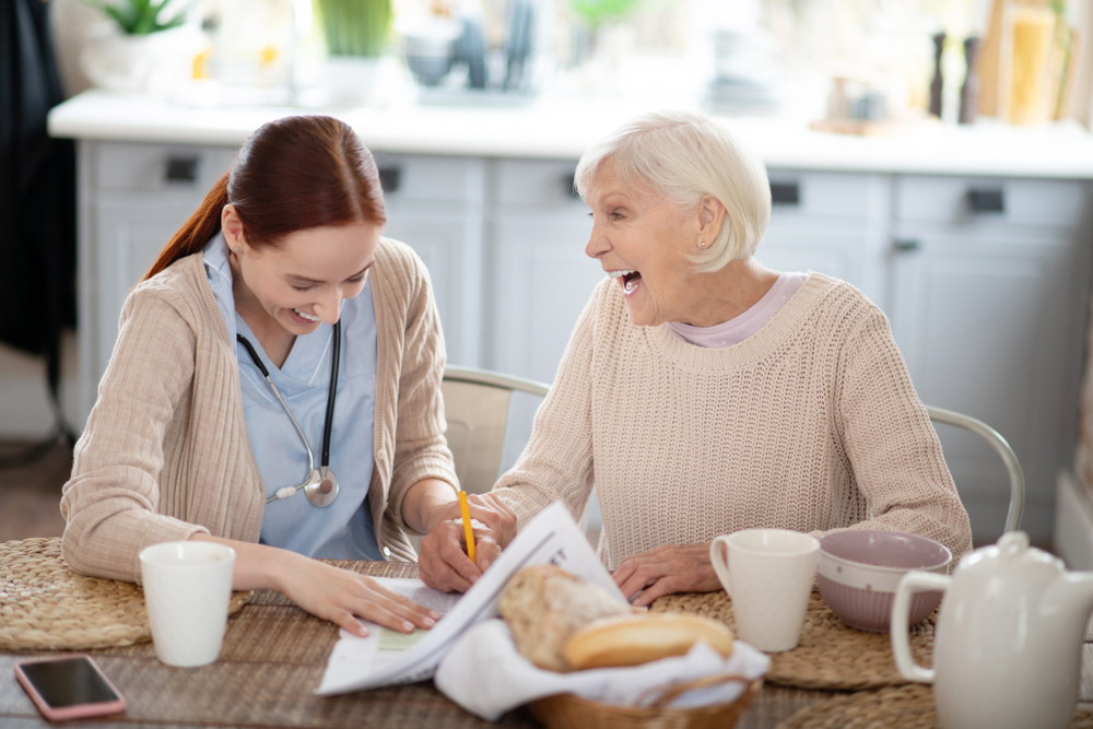 Nurse reviewing medications and paperwork with a senior woman